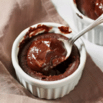 Gooey flourless chocolate lava cake on linen with spoon