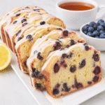 lemon blueberry pound cake sliced on marble kitchen counter.